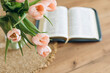 © sav_an_dreas - Open Bible and a bouquet of pink tulips on a wooden table at home. Copy space.