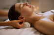 © Home-stock - Young lady client getting ear massage by professional masseuse in spa salon, lying in relaxed atmosphere, enjoying beauty treatment. Wellness acupressure manipulations