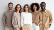 © perfectlab - Group of five diverse young adults standing together smiling against a plain white background in casual neutral-toned clothing