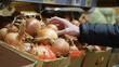 © fifthplanet - hand selecting fresh vegetables from a grocery display filled with colorful produce