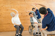© buritora - Senior men and women doing exercises and stretching at a nursing home, day care center, and staff
