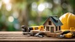 © Anat art - Model House With Construction Tools and Yellow Hard Hat on Wooden Table in Natural Light