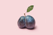 © Yaroslav Danylchenko/Stocksy - Split plum with leaf on pastel background