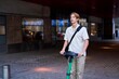 © Studio Sincère/Stocksy - Man Riding an Electric Scooter Down a City Street in the Evening