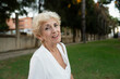 © Raul Navarro/Stocksy - Smiling senior woman in park