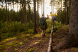 © Iuliia Versta/Stocksy - Father and son walking in the forest at sunset