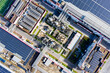 © Yic Ma/Stocksy - Aerial top view of industrial pipelines and solar panel rooftops