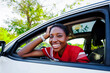 © BONNINSTUDIO/Stocksy - Smiling woman enjoying road trip leaning out car window