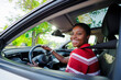 © BONNINSTUDIO/Stocksy - Cheerful woman driving modern car, enjoying road trip