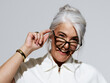© Leandro Crespi/Stocksy - Confident Older Woman Smiling While Adjusting Stylish Glasses