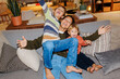© BONNINSTUDIO/Stocksy - Mother and two boys enjoying happy family moment on sofa ugc