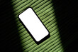 © Tatyana Lavrova/Stocksy - Smartphone With White Screen on Green Fabric Under Bright Light