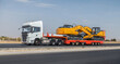 © kvdkz - Large truck is pulling a trailer with a yellow and black machine on it