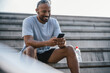 © Westend61 - Happy man using smart phone on staircase
