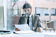 © BusinessClass by W61 - Businessman in suit reading document at modern office desk
