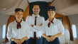 © Videophilia - Professional flight attendants and smiling pilot looking at camera, standing with crossed arms inside a luxurious private jet cabin, ready to provide excellent travel service