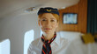 © Videophilia - Flight attendant smiling at camera while working inside a private jet airplane cabin, representing excellent service, hospitality, and comfortable luxury travel