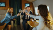 © Videophilia - Business people raising champagne glasses smiling and cheering, celebrating professional success, luxury travel, and achievements inside a private jet