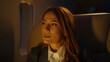 © Videophilia - Thoughtful businesswoman experiencing luxury travel, flying first class on a private jet at night, looking out the airplane window considering business strategy or future plans