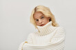 © LIGHTFIELD STUDIOS - Winter warmth captured in a cozy knitted sweater with a young blonde woman
