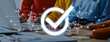 © InfiniteFlow - Members of a business team collaborate in a bright workspace. A digital check mark signifies success and approval in their project efforts, showcasing modern teamwork. Trope