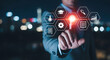 © HADI INCREDIBLE - Businessman touching virtual interface icons representing business and education applications in front of cityscape at night.