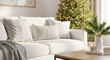 © julijadmi - Cozy living room with white sofa adorned with knitted pillows, decorated Christmas tree in the background creating a warm festive atmosphere