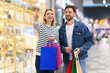 © New Africa - Happy couple with shopping bags walking in mall