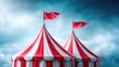 © Andrii  - Red and white circus tent with flags under cloudy sky