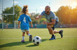 © miss irine - Dad plays football with daughter on green field. They have fun together during outdoor training. Father trains child with ball on sunny day. Happy family enjoys activity.