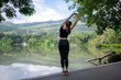 © Apichat - Woman stretching outdoors by lake for wellness