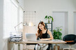 © Nuttapong punna - Smiling Asian woman standing and working with laptop in modern home office, concept of productivity, success, and female entrepreneurship.