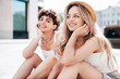 © halayalex - Two young beautiful smiling hipster female in trendy summer white t-shirt and shorts clothes. Sexy carefree women posing in the street. Positive models having fun, hugging and going crazy, sitting