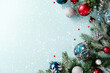 © photoguns - Christmas composition with pine branches, shiny baubles, stars, and snow on blue background. Right side decorated, left side empty for text.