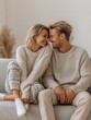 © Vero - Happy couple in cozy winter clothing cuddling on sofa at home