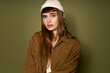 © Bliss - Stylish young woman poses with confidence against a textured green background