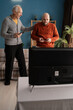 © Andrii Lysenko - Old Father and mature son play video games have fun at home.