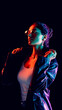 © master1305 - Confident woman adjusting leather jacket in colorful cinematic neon light. Concept of emotional marketing, brand storytelling, music industry visuals, and modern lifestyle promotion.