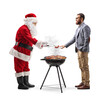 © Ljupco Smokovski - Santa claus grilling meat on a bbq and giving a sausage to a man