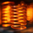 © yulya - Macro shot of copper coil illuminated by warm light. Represents energy flow and precision. Perfect for power, technology, and abstract design visuals