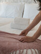 © AAlves - Detail of a person carefully arranging soft blanket on a modern bed, illustrating comfort, care, and hospitality in a welcoming, peaceful, and well-designed home or guest accommodation.
