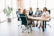 © deagreez - Team of coworkers in a modern office brainstorming ideas during a formal business meeting for a new corporate project