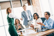 © deagreez - Team of professional colleagues shaking hands and collaborating in a modern office meeting filled with positivity and teamwork