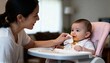 © Ksenia - Mom wiping babys face with tissue in natural indoor light with calm intimate mood and food detail