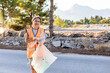 © ADDICTIVE STOCK - Middle-aged woman volunteer tidying roadside litter