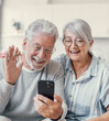 © Daniel - Happy retired family couple using mobile phone for video call together, talking to relations, getting good news, having fun, smiling and laughing. Carefree mature pensioners chatting online on cell