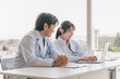 © buritora - A male supervising doctor and a female trainee doctor are receiving training while looking at electronic medical records on a computer
