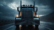 © Keopaserth - Rugged heavy duty semi truck front view driving through pouring rain at night with illuminated headlights and wet reflective highway, dramatic moody atmosphere and powerful presence