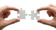 © Shoraoddi_Hossain - Hands connecting two blank puzzle pieces, representing solution and teamwork.