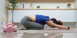 © Natee Meepian - Yoga and Mindfulness. Young woman practicing child pose at home.